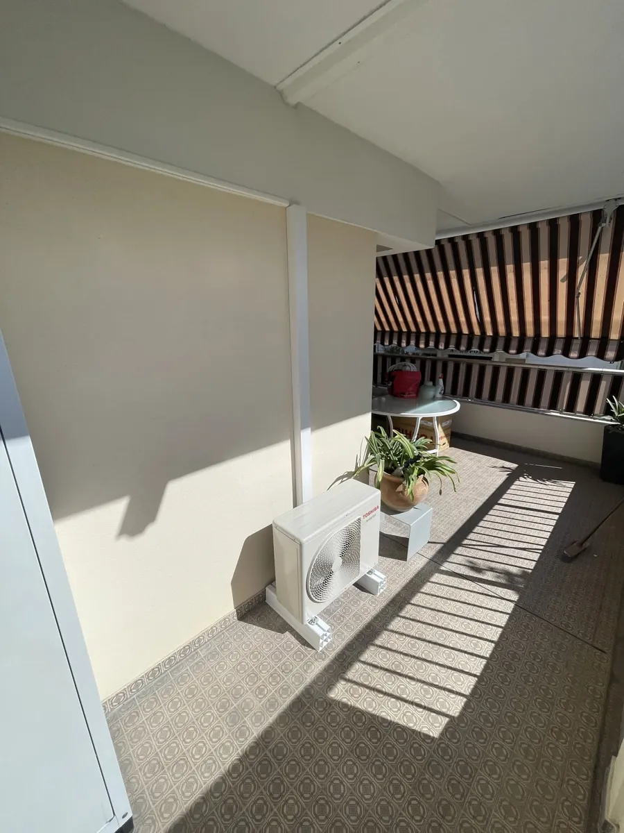 Groupe extérieur de climatisation installé sur une terrasse d'appartement