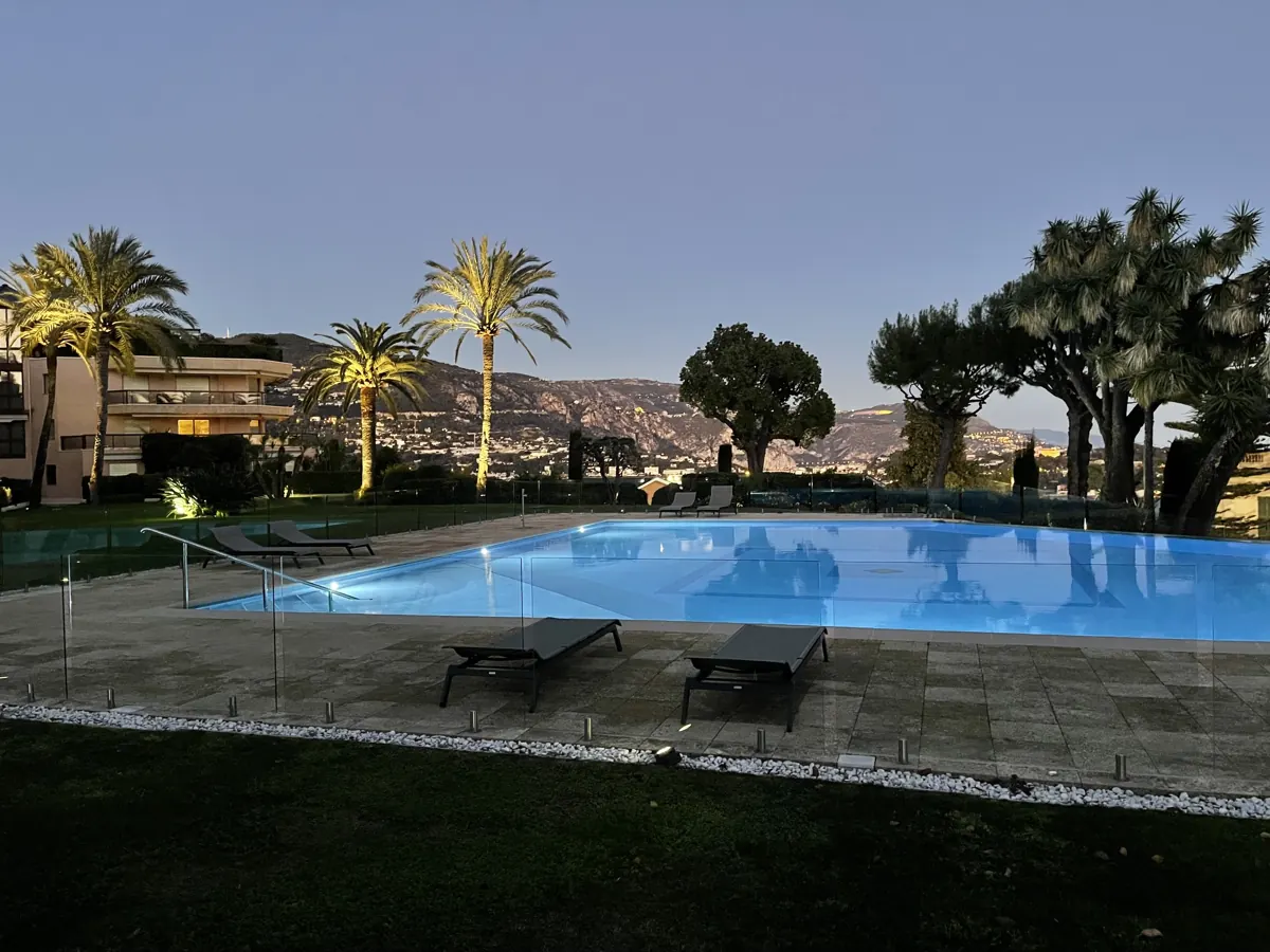 Piscine de résidence entourée de palmiers, de jour