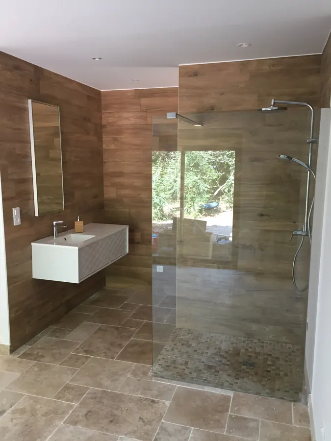 Douche à l'italienne avec paroi vitrée, carrelage imitation bois et meuble vasque suspendu