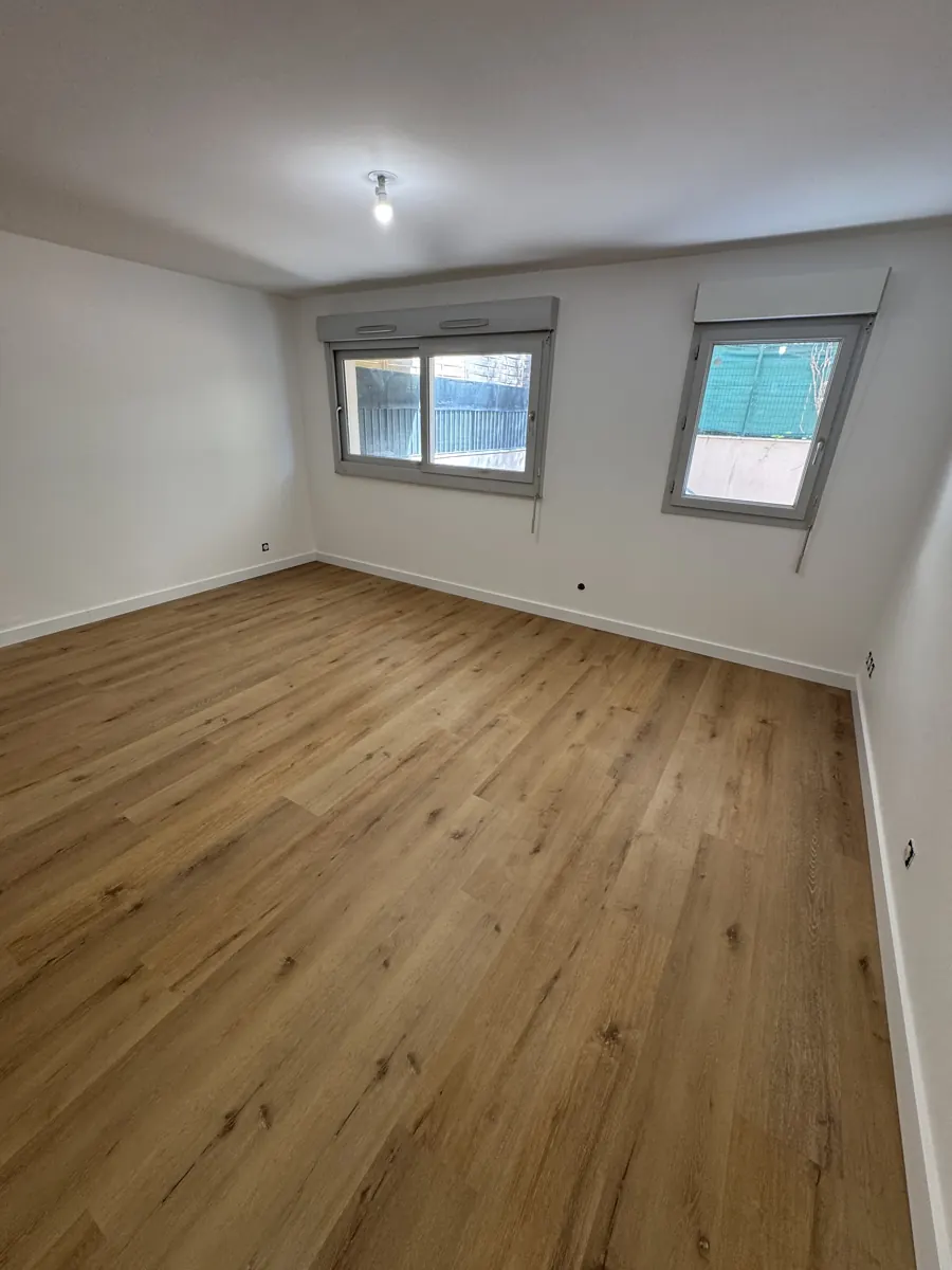 Chambre avec parquet chêne clair et deux fenêtres