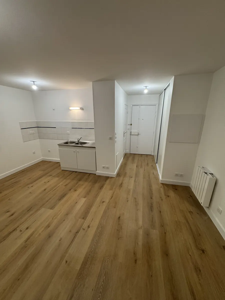 Cuisine et couloir avec parquet, meuble évier et radiateur