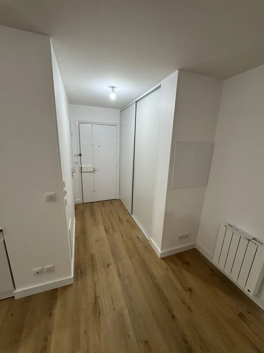 Entrée avec parquet et placards coulissants blancs