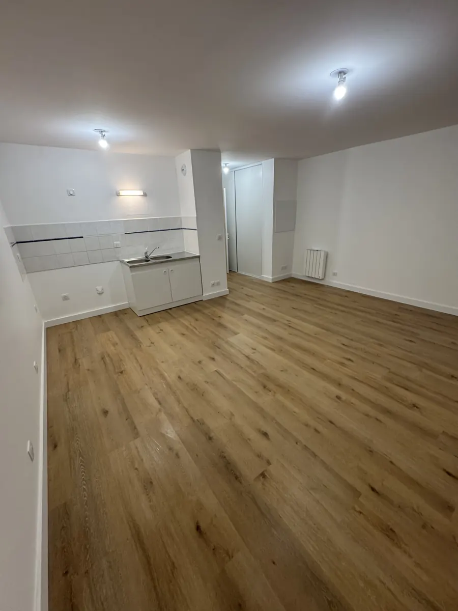 Séjour avec coin cuisine, parquet stratifié chêne clair posé