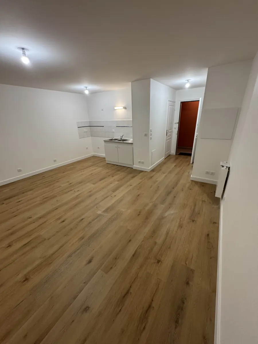 Séjour avec parquet, vue vers l'entrée et la cuisine